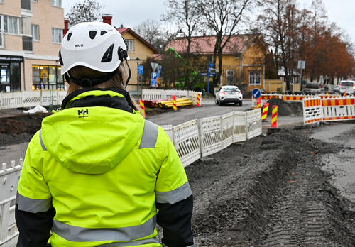 Työnjohtaja valvoo työmaata selkä kameraan päin Naantalin Kaivokadulla.