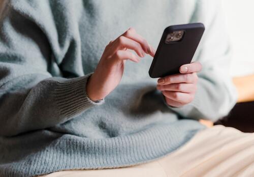 Henkilö näppäilee älypuhelinta.