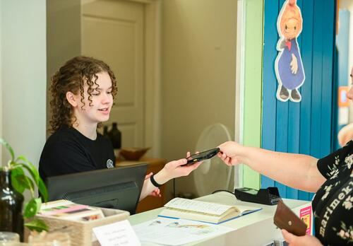 Kesätyöntekijä palvelee asiasta Naantalin museossa.