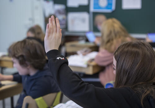 Oppilas viittaa luokassa.