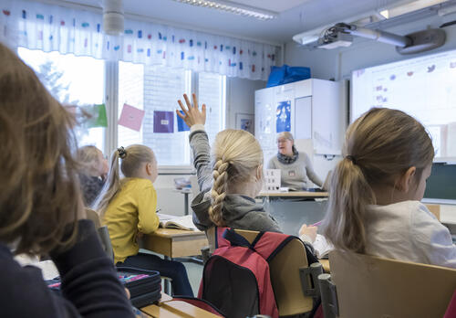 Oppilas viittaa luokassa