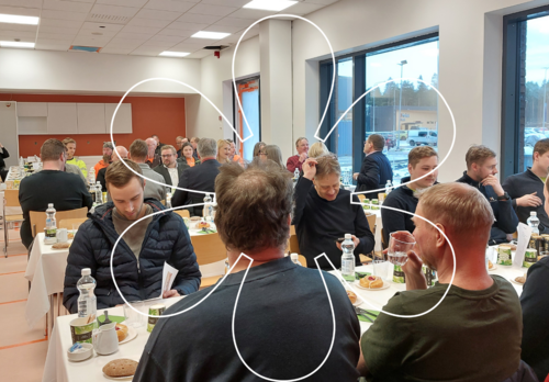 Ihmisiä pöytien ääressä syömässä hernekeittoa. Kuvan päällä Onnellinen aurinko -tunnus.