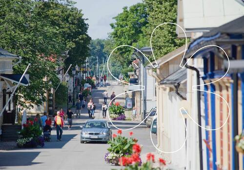 Ihmisiä kulkee puutalojen välissä Mannerheiminkatua pitkin kesäisessä Vanhassakaupungissa Naantalissa.