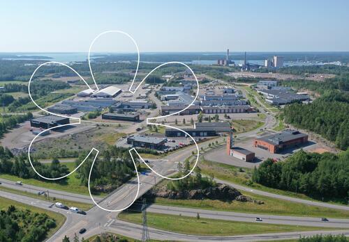 Luolalan yritysalueen isoja hallirakennuksia. Onnellinen aurinko -elementti.