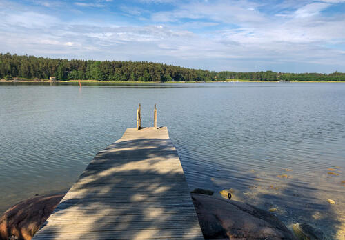 Laituri vie mereen. Horisonttissa näkyy metsää.