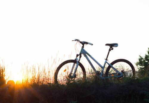 Polkupyörä niityn keskellä auringonlaskussa.