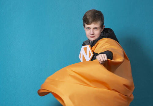 Poika oranssissa Naantali-supersankariviitassa.