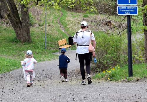 Äiti kolmen lapsensa kanssa siivoamassa rantaa Nunnalahdessa.