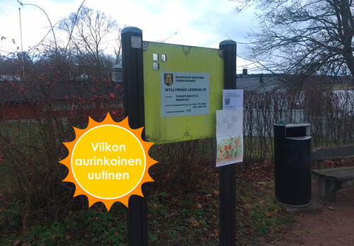 Leikkipuistossa kyltti, johon on kiinnitetty lukutehtävät paperein. Viikon aurinkoinen uutinen.