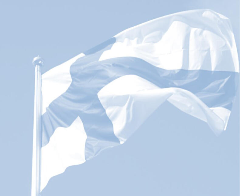 Suomen lippu hulmuaa tuulessa
