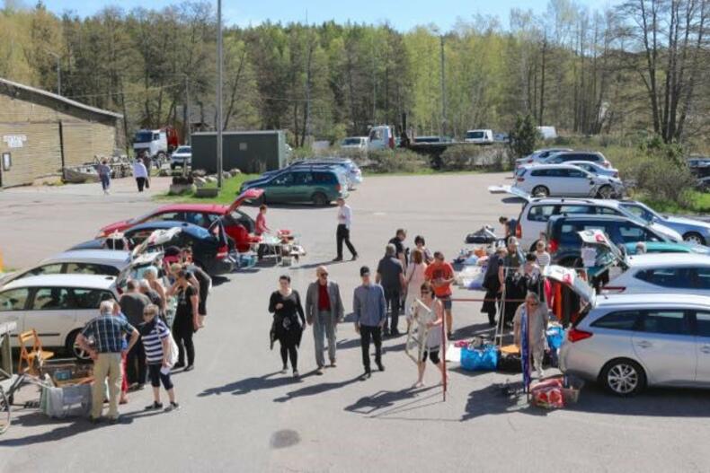 Peräkonttikirppis Röölän rannassa: Autoja rivissä ja ihmisiä kulkemassa autojen välissä