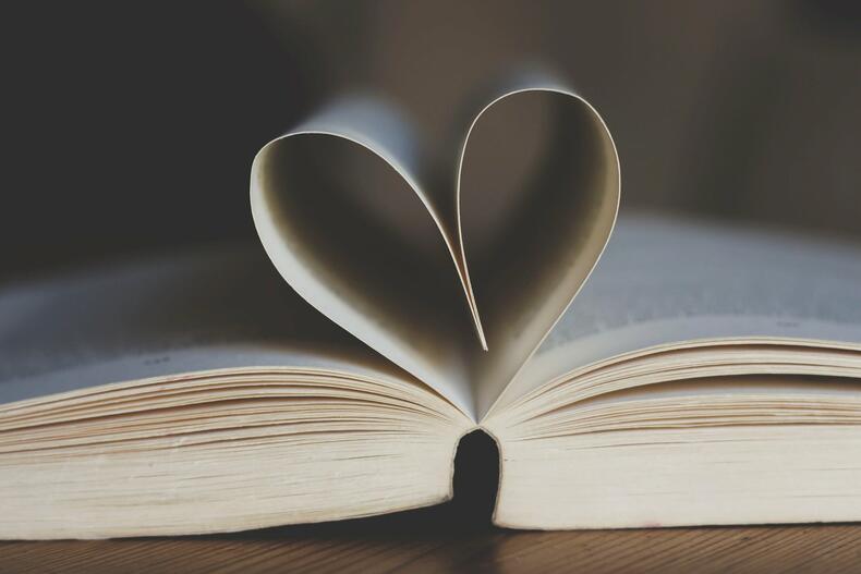 Kirja, joka on aukaistu keskelta, ja jonka keskimmäiset sivut on käännetty sydämen muotoon.