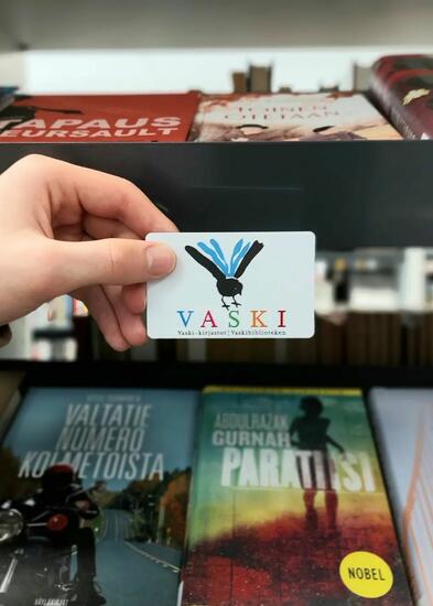 Kädessä Vaski-kirjastokortti