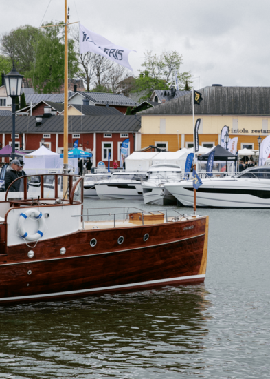 Ihmisiä veneessä Naantalin Vanhankaupungin rannassa.