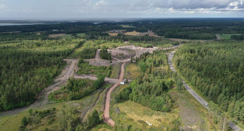 Dronella kuvatussa maisemssa näkyy oikealla isompi tie sekä työmaata, jossa katuja rakennetaan metsän keskelle.