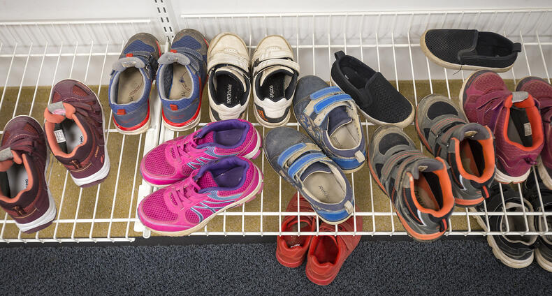 Paljon lasten kenkiä kenkätelineessä.