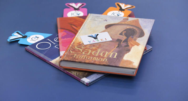 Satukirjoja ja Vaski-kirjastokortti pöydällä