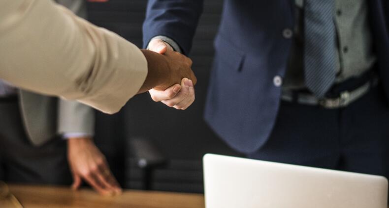 Kaksi miestä kättelee toisiaan