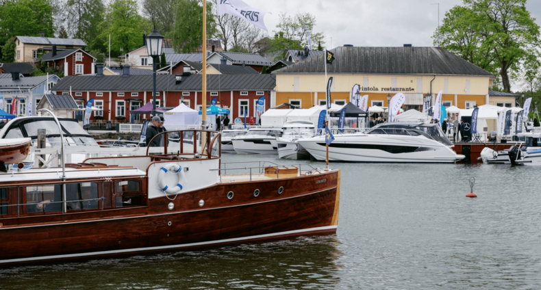 Ihmisiä veneessä Naantalin Vanhankaupungin rannassa.