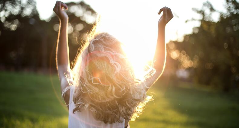 Nuori kulkee puistossa auringon paisteessa